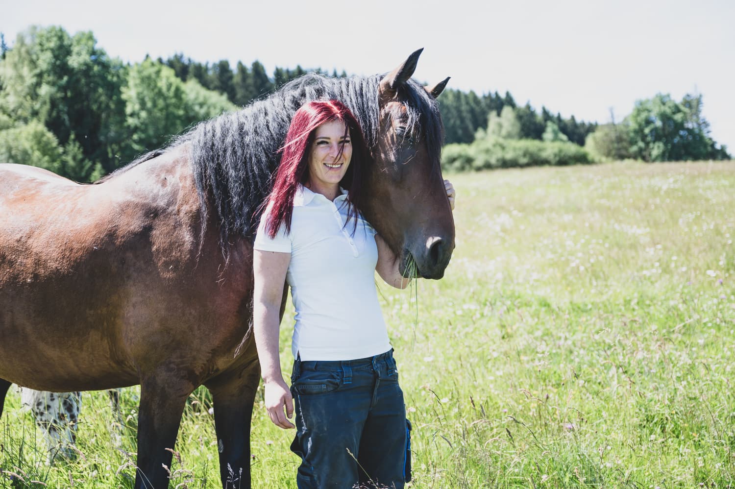 Sabine Thur mit einem Pferd auf der Weide